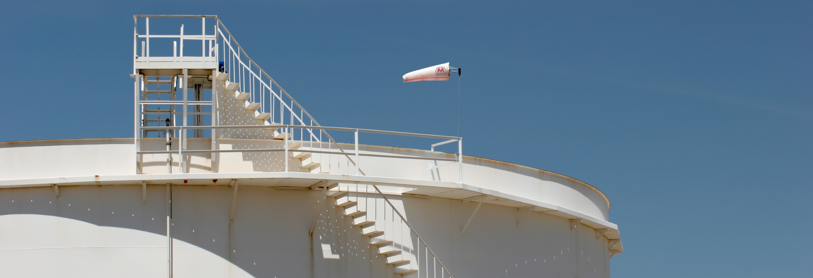 Custom printed Marathon windsock on top of oil storage tanks